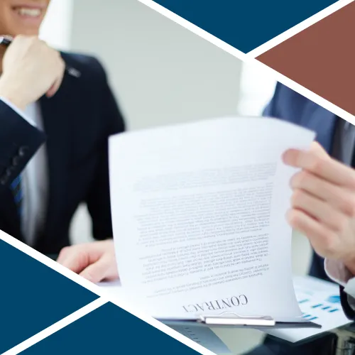 Primo piano di un professionista in abito scuro che tiene in mano un contratto con la scritta "CONTRACT" chiaramente visibile in fondo alla pagina.